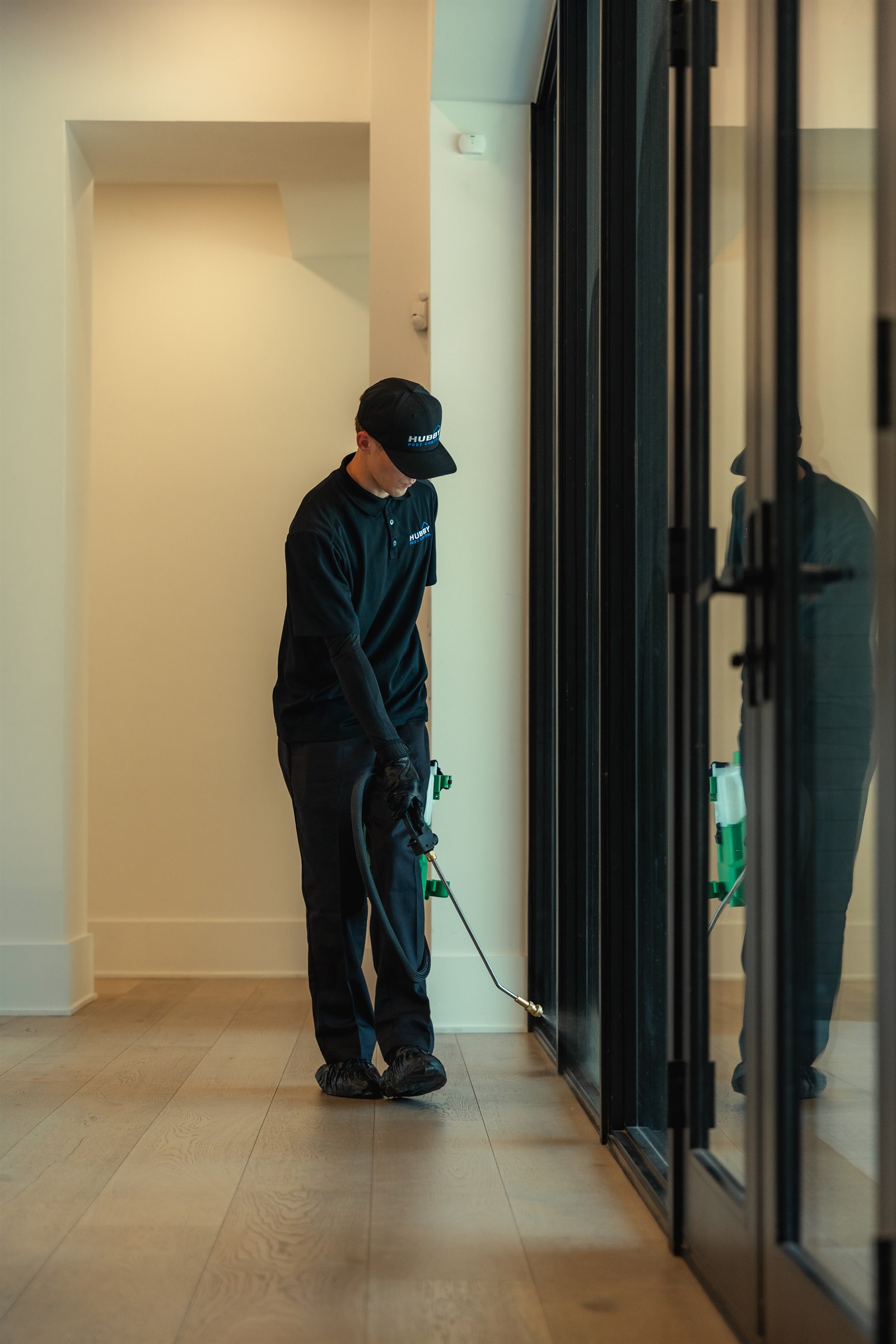 Hubby Pest Control technician treating an interior door frame